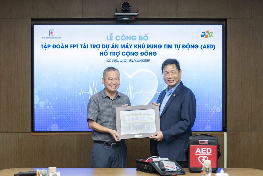 PGS.TS Nguyễn Lân Hiếu - Giám đốc Bệnh viện Đại học Y Hà Nội (bìa trái) và Chủ tịch Tập đoàn FPT Trương Gia Bình tại lễ công bố (Ảnh: BTC).