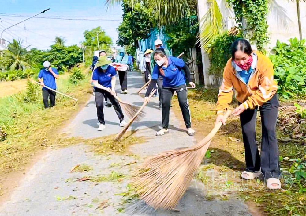 Phụ nữ xã Trà Cú quét dọn, vệ sinh đường làng, ngõ xóm đón Tết Độc lập. Ảnh: THẠCH HOÀNG

