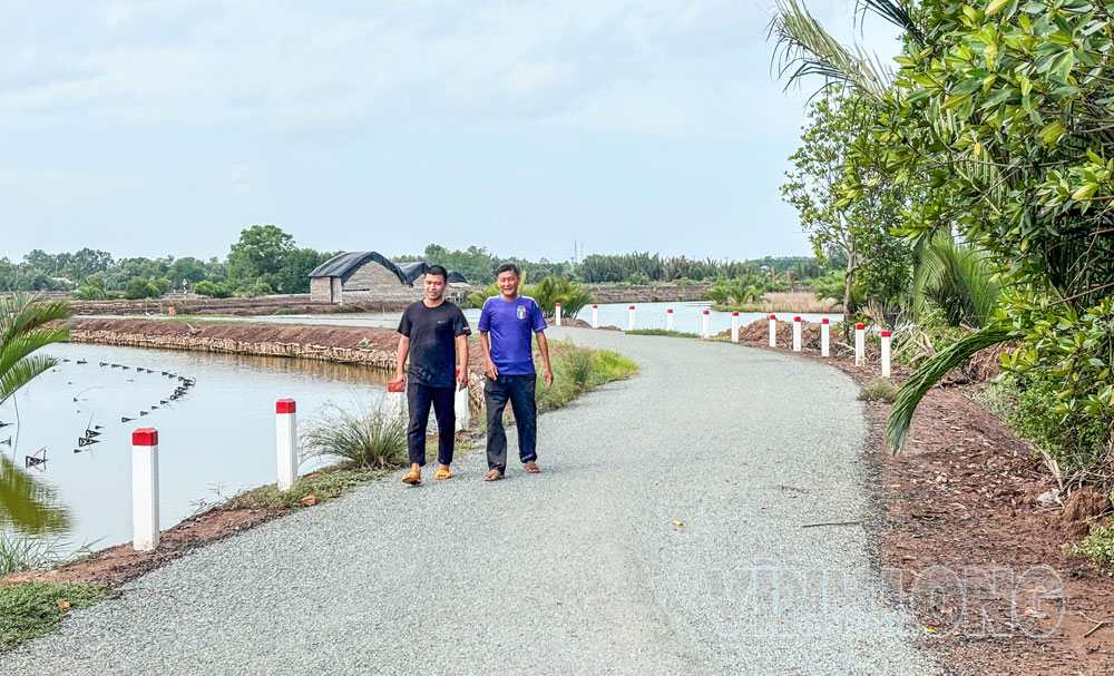 Anh Nguyễn Duy Tú (trái) đã hiến đất để cùng Nhà nước xây dựng tuyến đường liên xã Long Thành- Long Vĩnh- Đông Hải, giúp vận chuyển nông sản thuận lợi, nâng cao giá trị kinh tế. Ảnh: XUÂN TƯƠI

