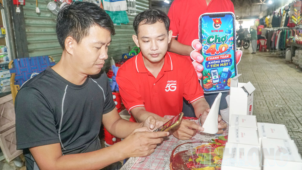 Anh Phạm Quốc Công- chủ tiệm trà sữa Bối tại chợ Phú Quới, được hướng dẫn cài đặt mã QR tích hợp loa thông báo giao dịch tự động.