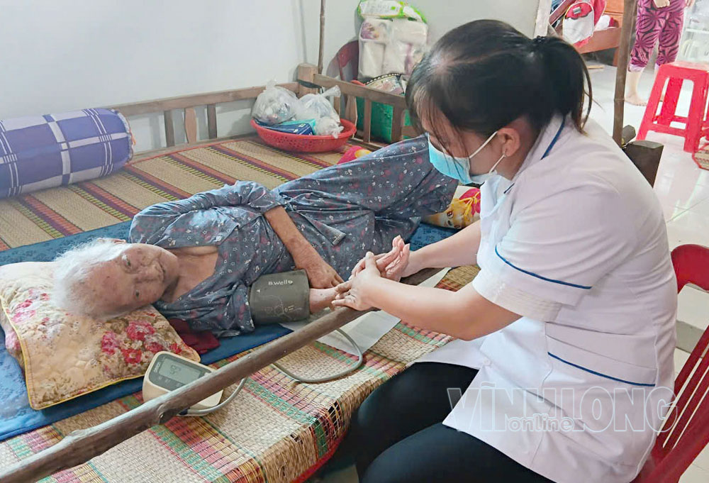Thành viên Tổ khám sàng lọc tại nhà của Trạm Y tế xã Bảo Thạnh khám sàng lọc sức khỏe cho người dân ngay tại nơi ở. Ảnh: PHAN HÂN