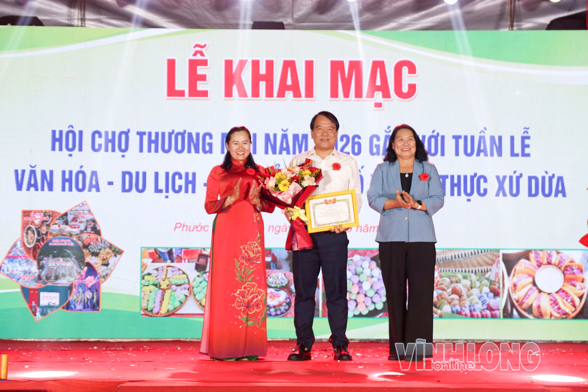 Phó Chủ tịch UBND tỉnh Nguyễn Thị Bé Mười và Bí thư Đảng ủy xã Phạm Thị Thanh Thảo trao hoa và giấy khen cho đơn vị hỗ trợ kinh phí thực hiện an sinh xã hội tại xã Phước Mỹ Trung.