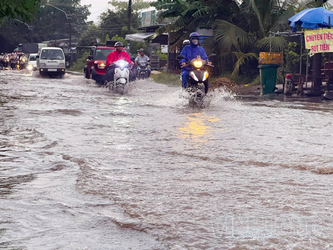 Quốc lộ 53, đoạn đi qua xã Long Hồ bị ngập sau mưa lớn và nước triều dâng, gây khó khăn cho người tham gia giao thông.