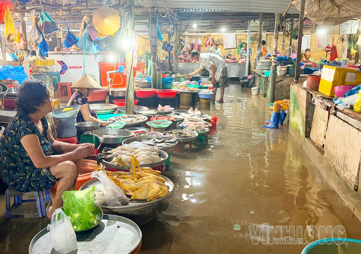 Nước triều dâng vào khu vực mua bán, ảnh hưởng đến hoạt động kinh doanh của tiểu thương.