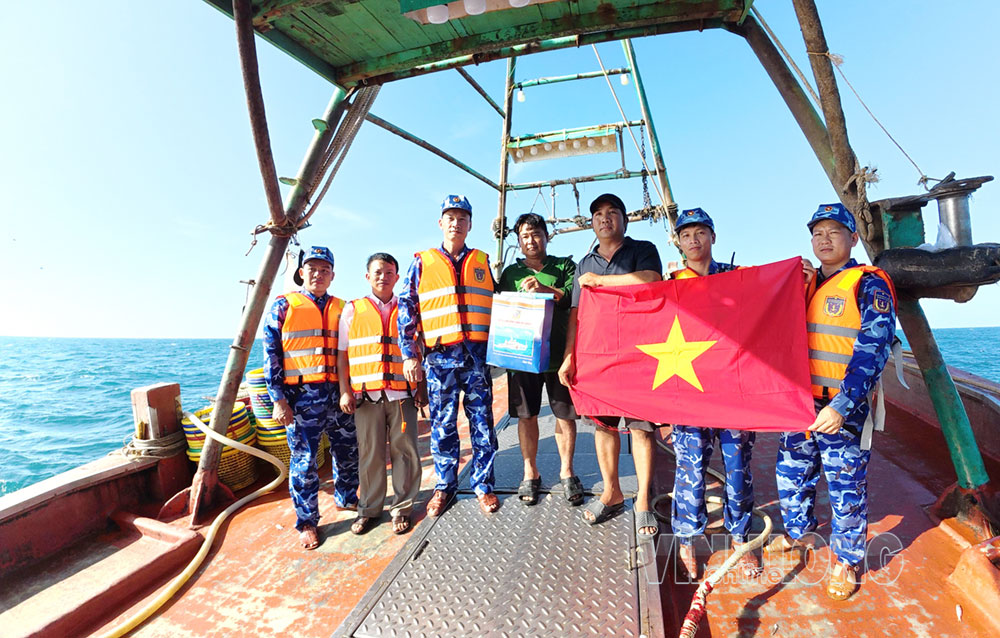 Tặng quà và cờ Tổ quốc cho ngư dân trên biển.