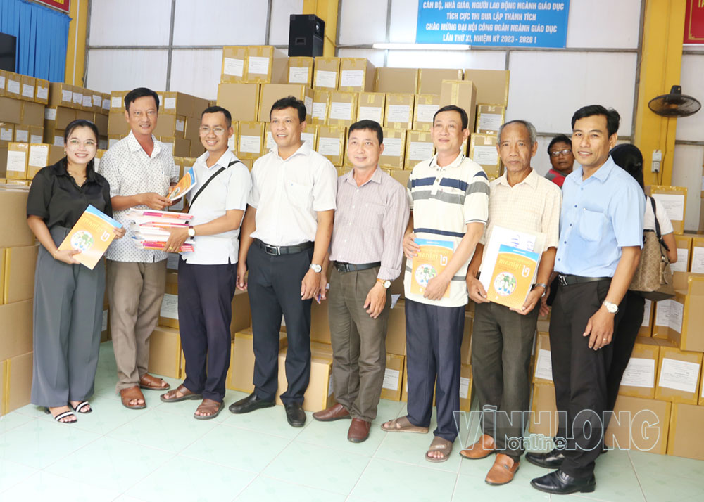Đại diện các chuyên môn Sở Giáo dục và Đào tạo trao sách chữ Khmer cho các trường.