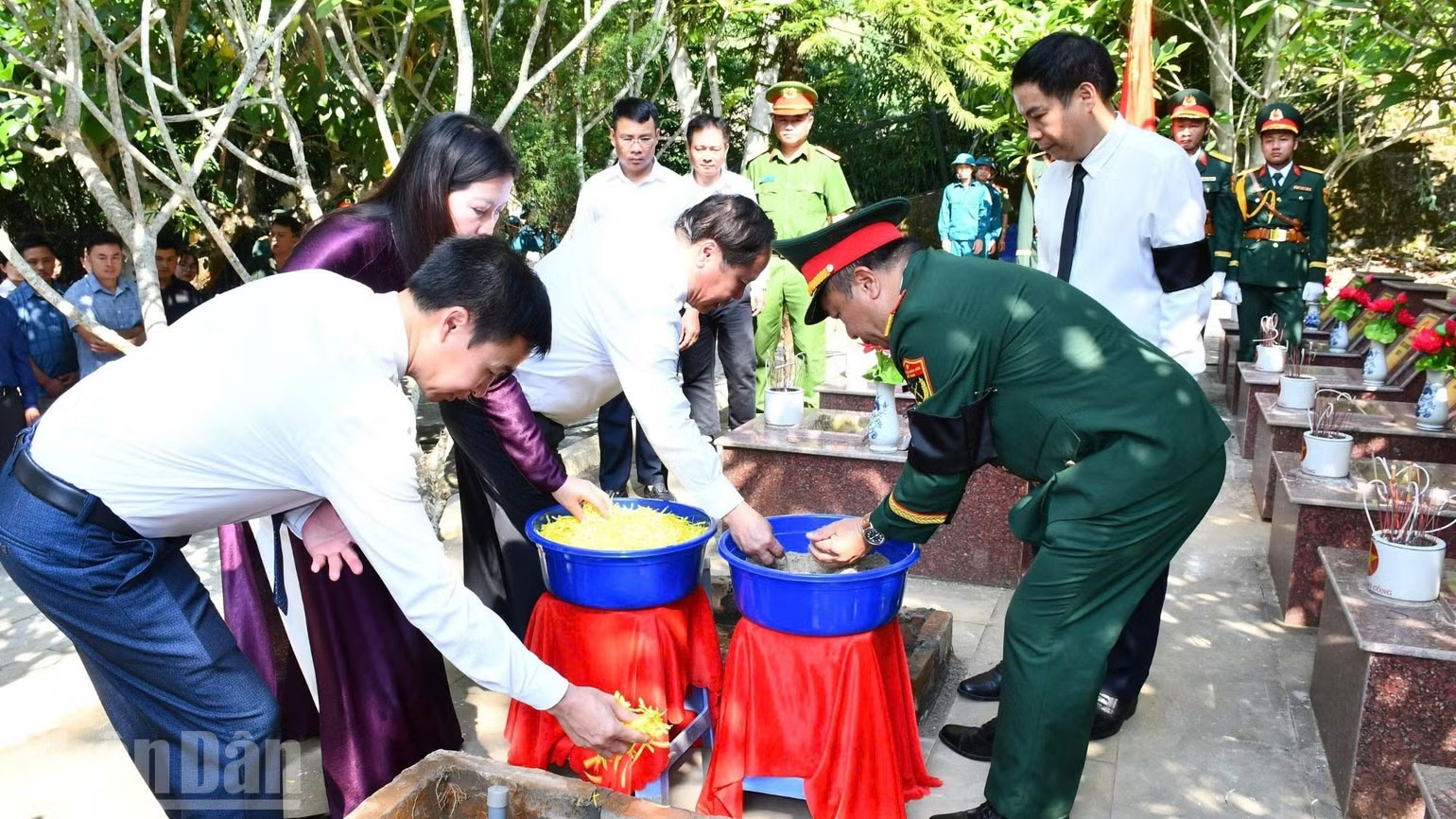 Các đại biểu thực hiện nghi lễ an táng hài cốt các liệt sĩ.
