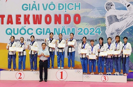 Các VĐV ĐT taekwondo Vĩnh Long trên bục nhận HCV nội dung quyền tiêu chuẩn đồng đội nữ.

