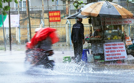 Nhiều người cố tình chạy xe vào những làn nước ngập sâu, kéo ga mạnh để xe lướt nhanh làm nước văng tung tóe. Ảnh: QUỐC NGUYÊN (TP Vĩnh Long)

