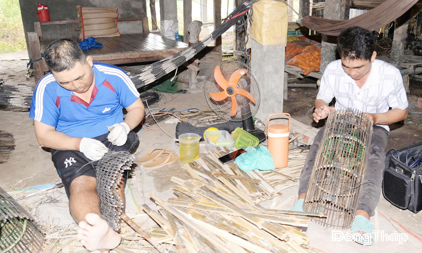 Anh Nguyễn Văn Đoàn (bìa trái) thực hiện công đoạn đan lọp cua đồng.    
