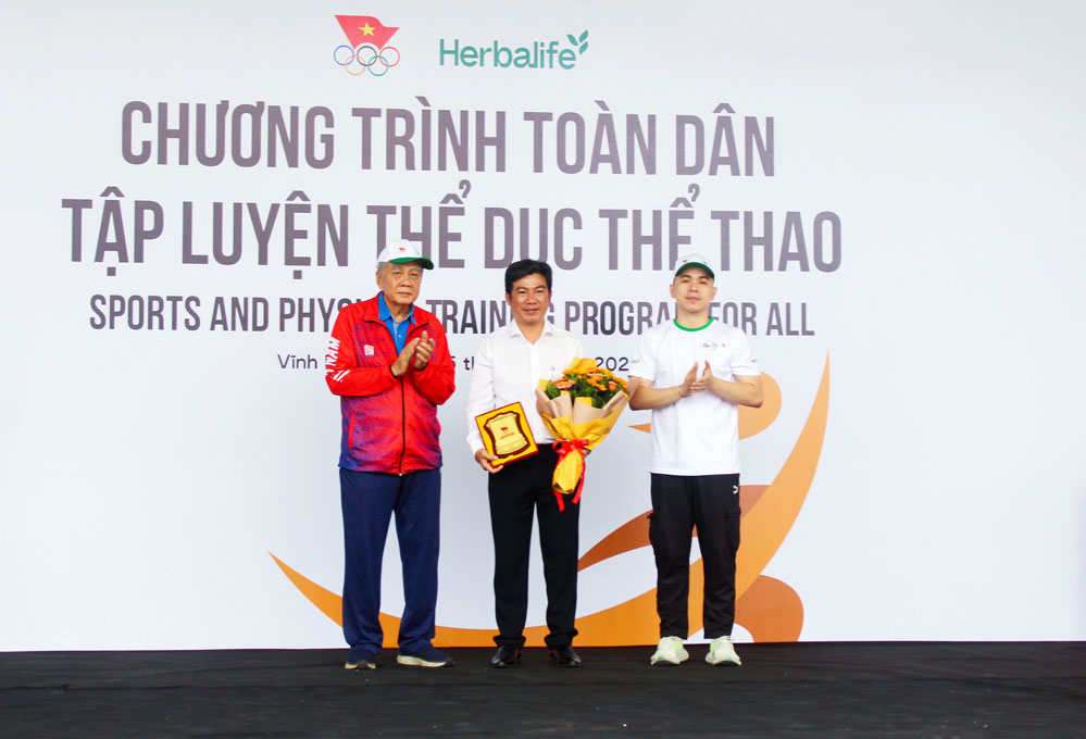 Đại diện Sở Văn hóa, Thể thao và Du lịch nhận hoa và kỷ niệm chương cho ban tổ chức địa phương.

