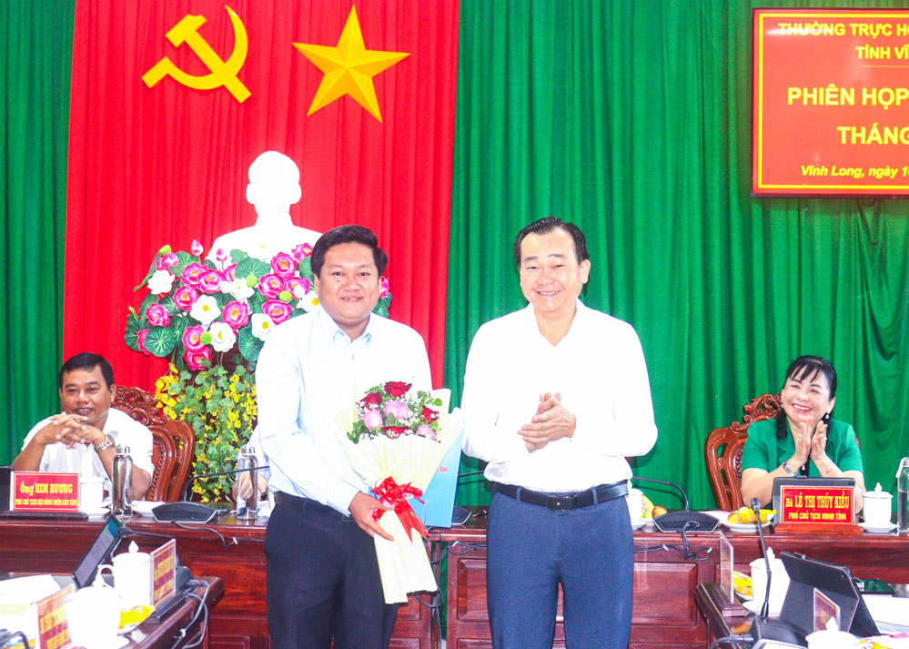 Đồng chí Nguyễn Minh Dũng- Phó Bí thư Tỉnh ủy, Chủ tịch HĐND tỉnh trao nghị quyết và tặng hoa chúc mừng đồng chí Lâm Văn Phong giữ chức Phó Trưởng Ban Dân tộc HĐND tỉnh Vĩnh Long khóa X.
