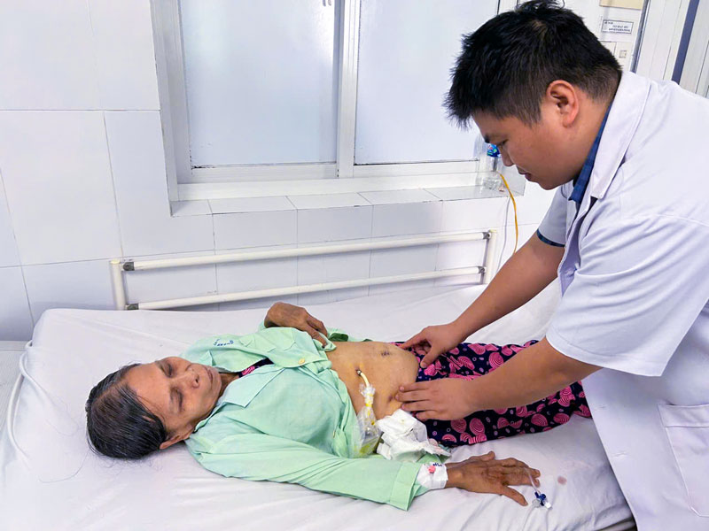 BS.CKI Trần Nhật Phi thăm khám cho bệnh nhân sau mổ.