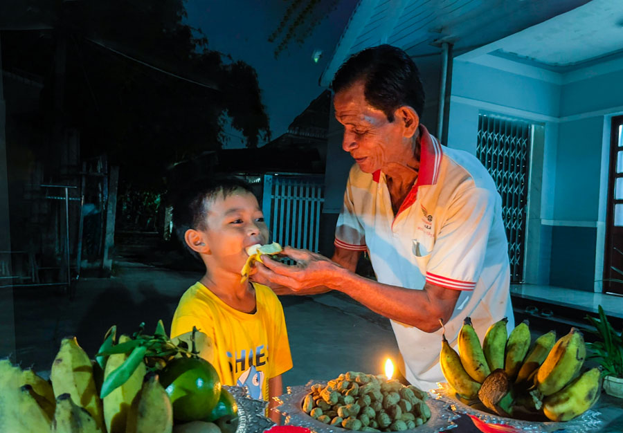 Ông Thạch Sa Mươne đút cốm dẹp cho cháu và chúc những điều ước sẽ thành hiện thực.