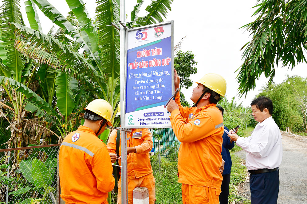 Công nhân ngành điện gắn biển công trình.