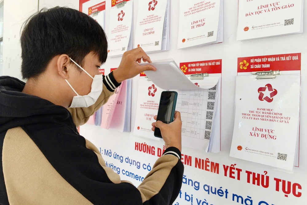 Người dân xã Châu Thành tra cứu thông tin thủ tục hành chính nhanh chóng thông qua mã QR được niêm yết tại TTPVHCC xã.