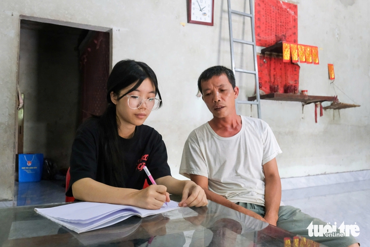 Hai bố con Âu Thu Hiền vạch ra những khoản tiền mà con phải trả trên Hà Nội như tiền nhà, tiền ăn, đi lại - Ảnh: HÀ QUÂN

