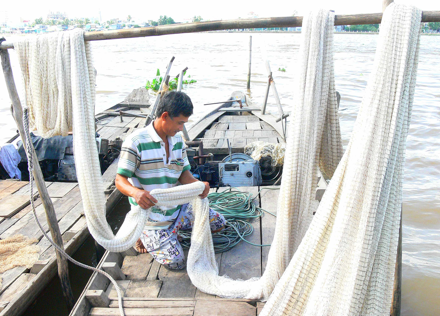 Ngư dân chuẩn bị chài, lưới khai thác cá trên sông. Ảnh: THÀNH CHINH