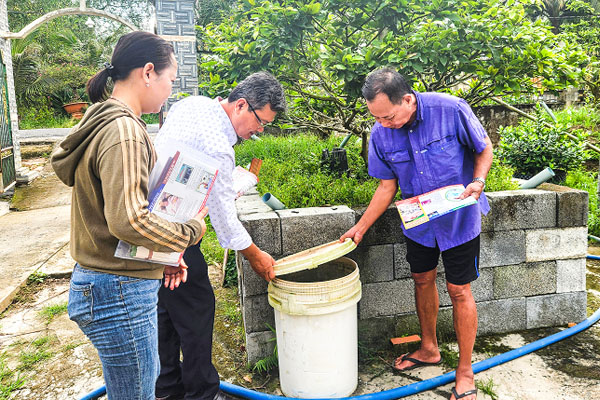 Trung tâm Y tế khu vực Long Hồ hướng dẫn người dân che đậy dụng cụ chứa nước phòng ngừa muỗi vằn đẻ trứng.