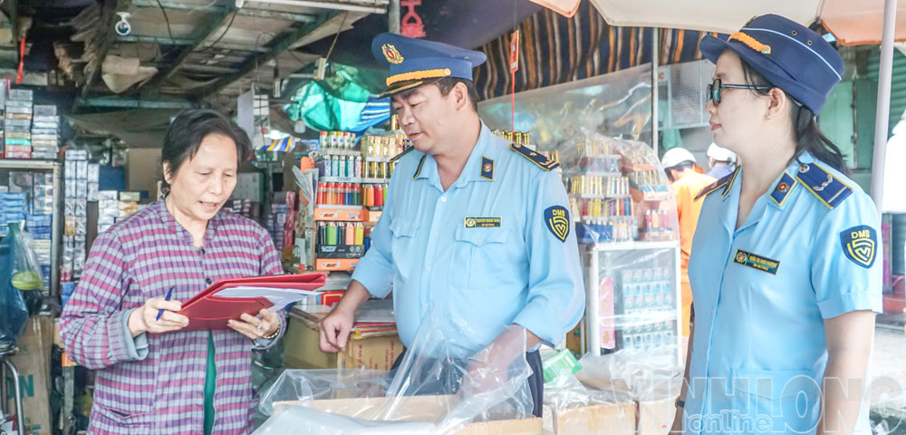 Lực lượng quản lý thị trường hướng dẫn tiểu thương tại chợ Vĩnh Long (phường Long Châu) chấp hành quy định về kinh doanh thuốc lá.

