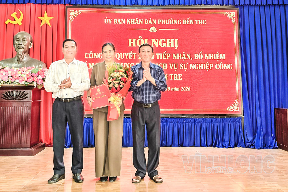 Lãnh đạo phường trao quyết định và hoa cho bà Trần Thị Bích Vân.