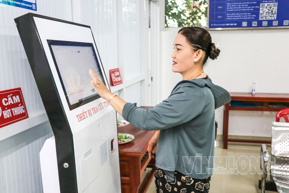 Người dân tiếp cận các tiện ích công nghệ số khi đến giải quyết thủ tục hành chính tại Trung tâm Phục vụ hành chính công xã Long Hồ.

