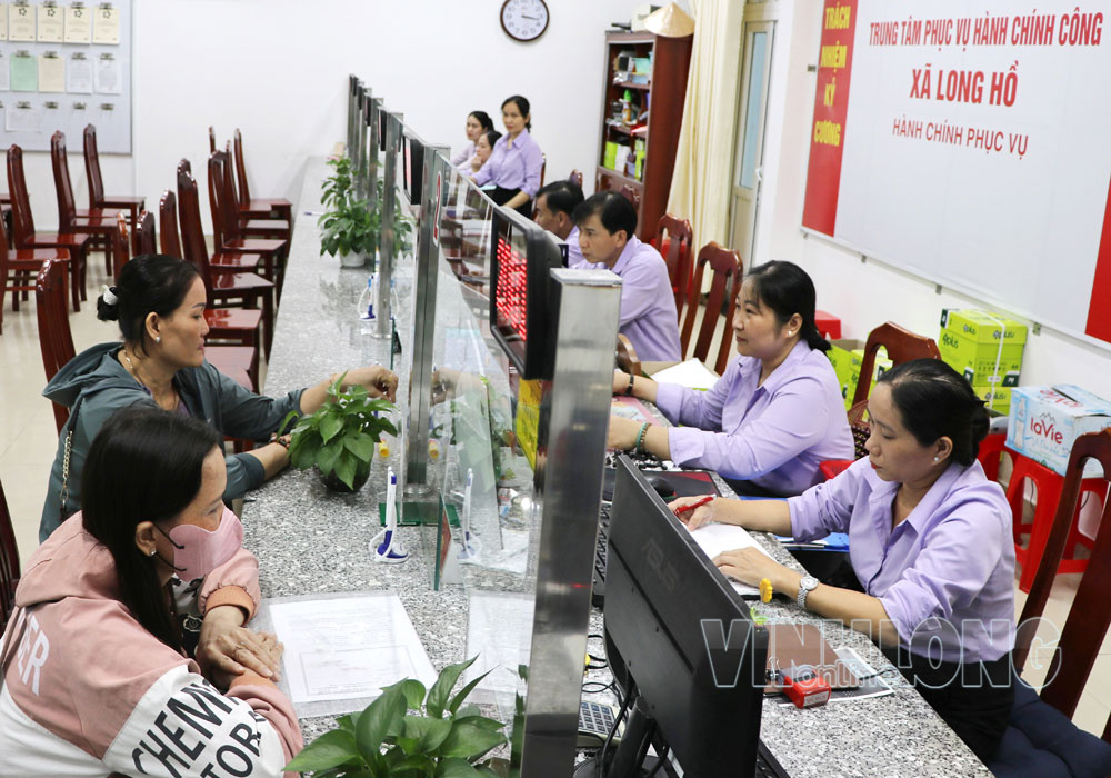 Công chức Trung tâm Phục vụ hành chính công xã Long Hồ giải quyết thủ tục hành chính cho người dân.

