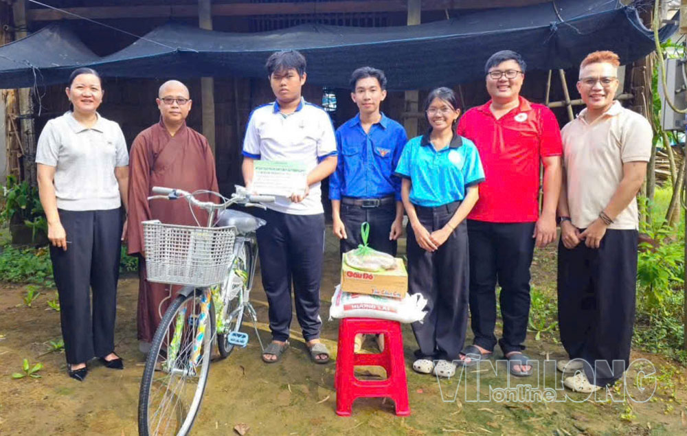 Anh Lý Minh Thuận (thứ 2 từ phải sang) phối hợp nhà hảo tâm tặng xe đạp và quà hỗ trợ học sinh hoàn cảnh khó khăn. Ảnh: NGỌC XOÀN