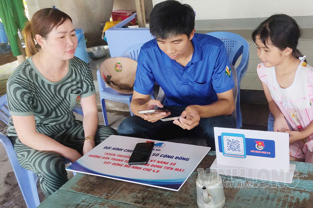 Đoàn viên, thanh niên xã Tân Long Hội hướng dẫn người dân sử dụng dịch vụ công trực tuyến, thanh toán không dùng tiền mặt.

