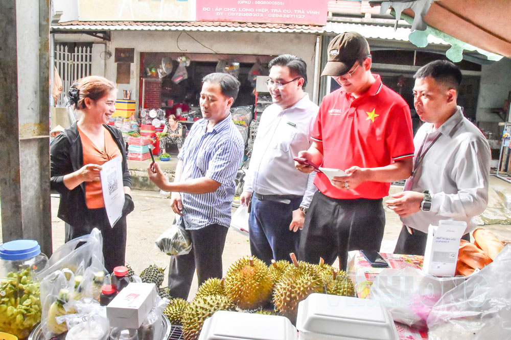 Khách hàng quét mã QR thanh toán không dùng tiền mặt tại chợ Long Hiệp.

