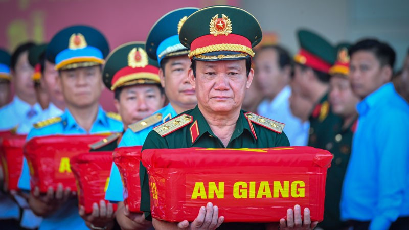 Trung tướng Hồ Văn Thái, Chính ủy Quân khu 9 trực tiếp nâng thùng mẫu hài cốt liệt sĩ trong nghi thức vận chuyển, bàn giao phục vụ giám định ADN. (Ảnh: PHƯƠNG VŨ)