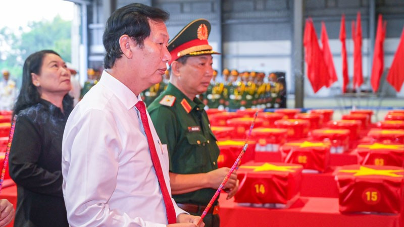 Trung tướng Hồ Văn Thái, Chính ủy Quân khu 9 trực tiếp nâng thùng mẫu hài cốt liệt sĩ trong nghi thức vận chuyển, bàn giao phục vụ giám định ADN. (Ảnh: PHƯƠNG VŨ)