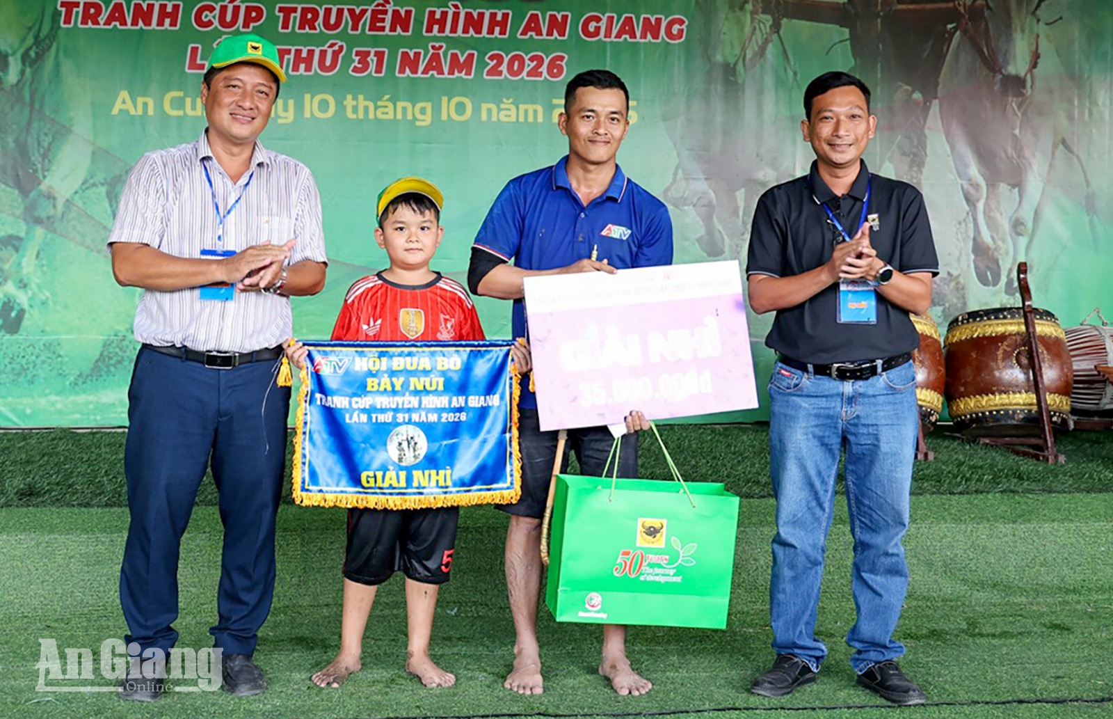 Phó Giám đốc Sở Văn hóa và Thể thao tỉnh An Giang Trần Nguyễn Bá (bìa trái) trao giải nhì cho gia đình ông Nguyễn Văn Lâm.