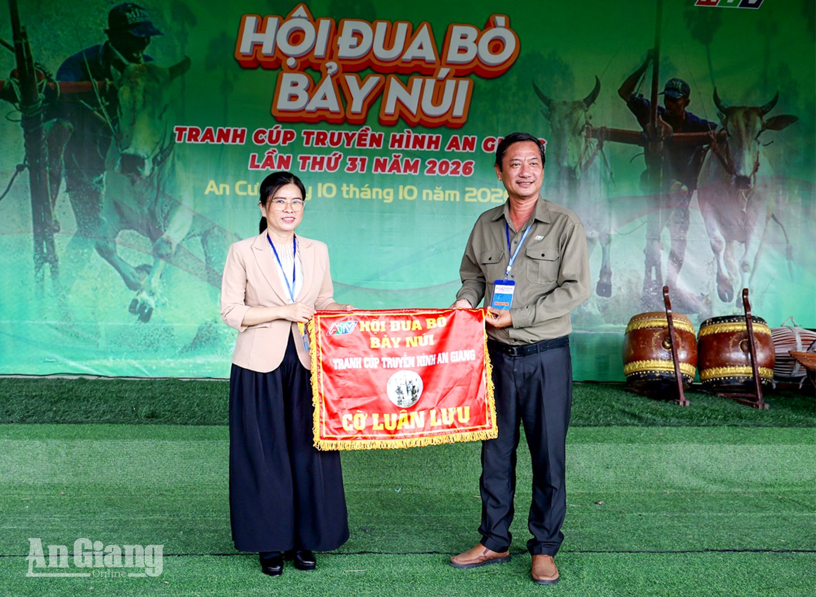 Giám đốc Báo và phát thanh, truyền hình An Giang Lê Văn Chuyển (bìa phải) trao cờ cho xã Tri Tôn - đơn vị đăng cai Hội Đua bò Bảy Núi tranh cúp Truyền hình An Giang (ATV) lần thứ 32, năm 2027.