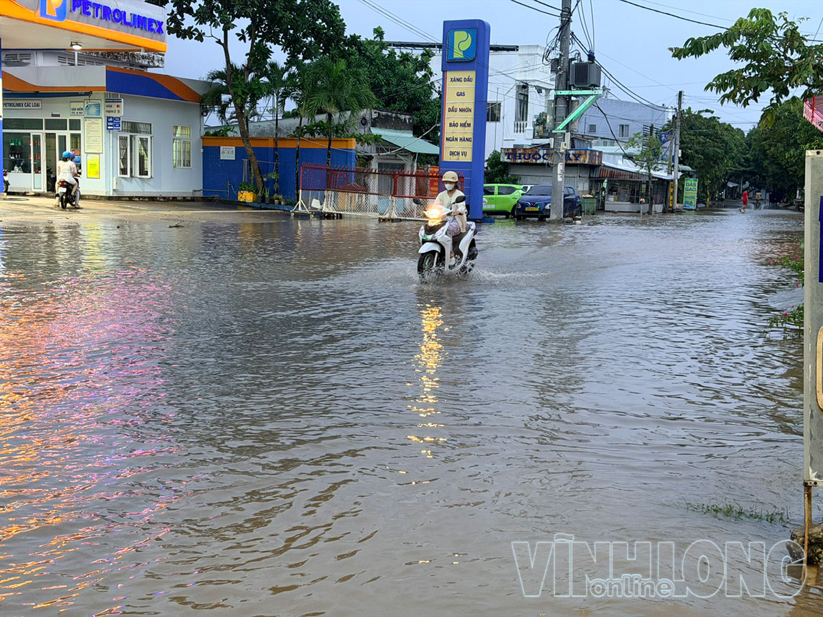 Triều cường gây ngập một số tuyến đường, ảnh hưởng đến việc đi lại của người dân.

