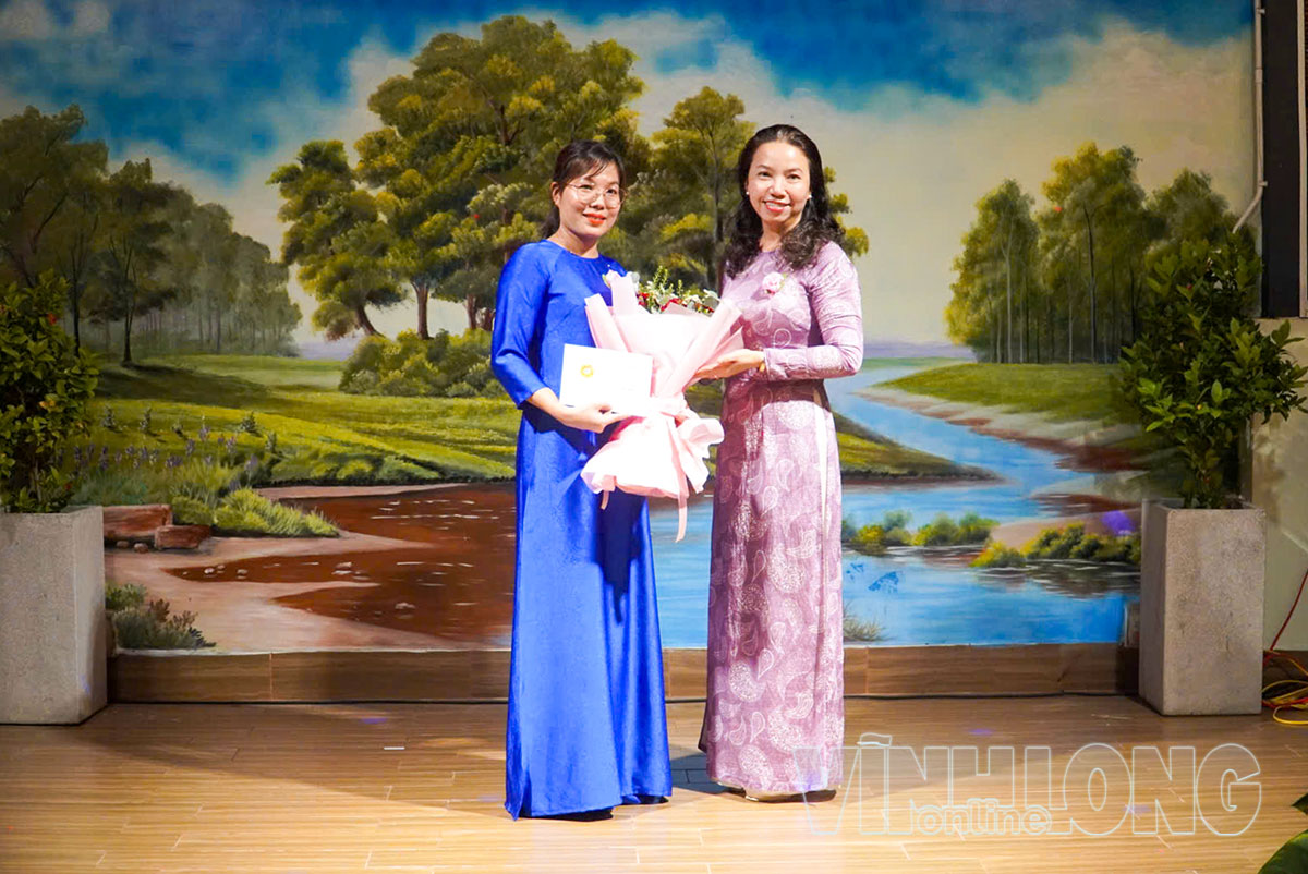 Chủ tịch Uỷ ban MTTQ phường Phú Khương - Phùng Anh Thục Đoan trao kỷ niệm chương cho bà Huỳnh Thị Tâm.