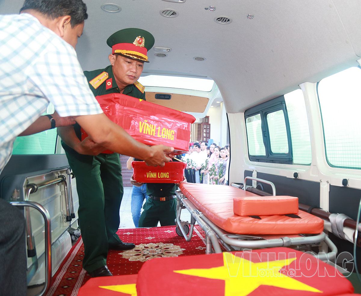 Đưa các thùng đựng mẫu hài cốt liệt sĩ lên xe chuyên dụng.