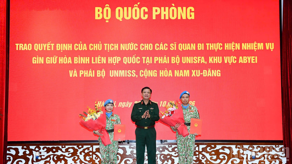 Thượng tướng Nguyễn Trường Thắng trao quyết định cho hai sĩ quan. (Ảnh: THẾ ĐẠI)
