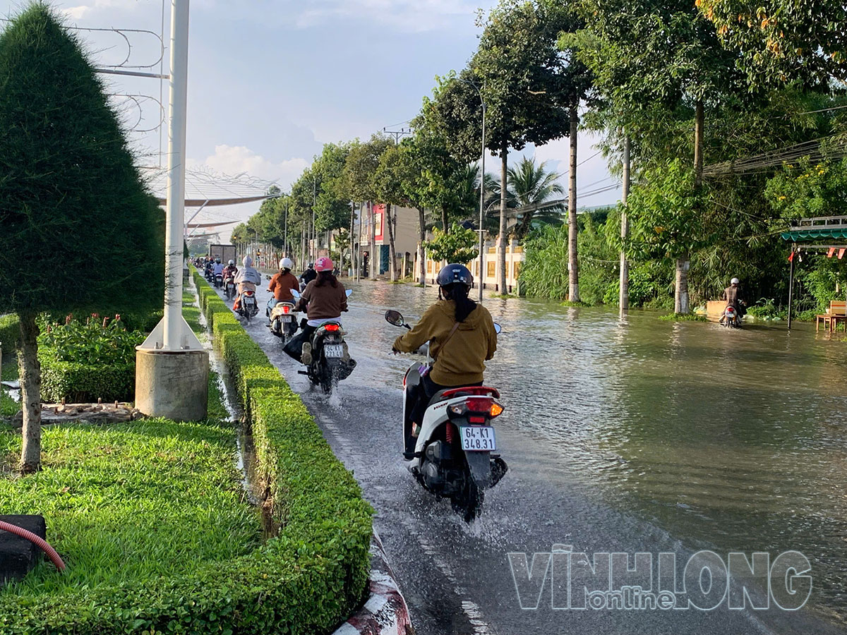 Nhiều phương tiện phải di chuyển chậm, nối đuôi nhau để vượt qua đoạn đường ngập.