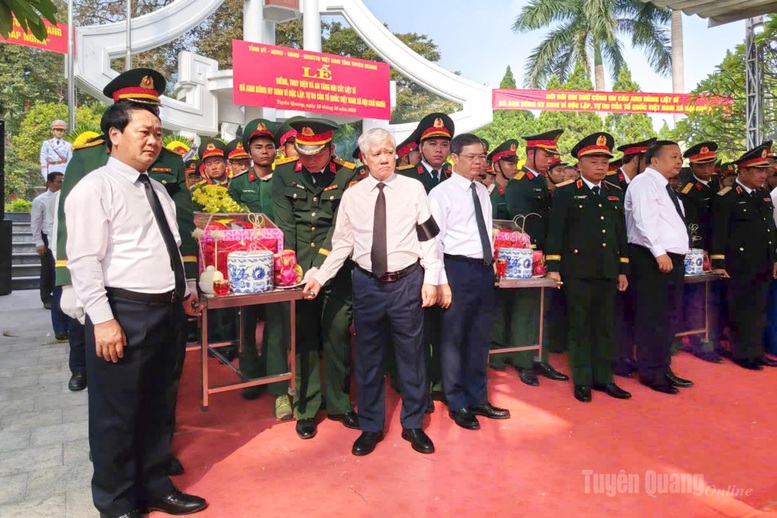 Phó Chủ tịch Thường trực Quốc hội Đỗ Văn Chiến và Bí thư Tỉnh ủy Tuyên Quang Hầu A Lềnh di chuyển hài cốt liệt sĩ đến nơi an táng - Ảnh: Báo Tuyên Quang

