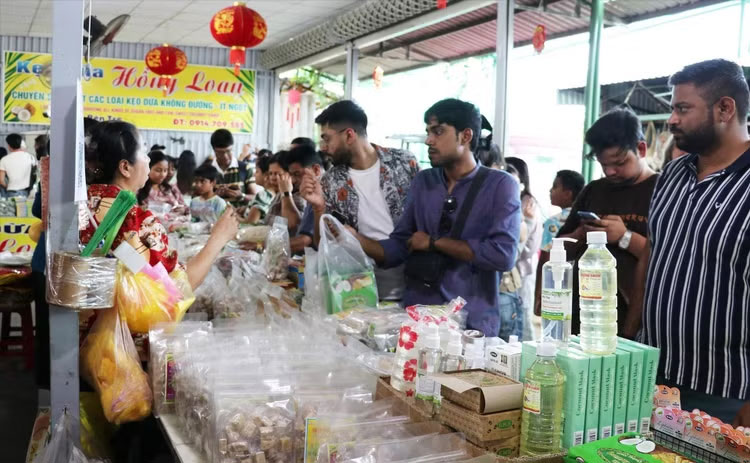 Khách quốc tế mua các đặc sản địa phương tại điểm du lịch cồn Thới Sơn, Đồng Tháp. (Ảnh: TTXVN)
