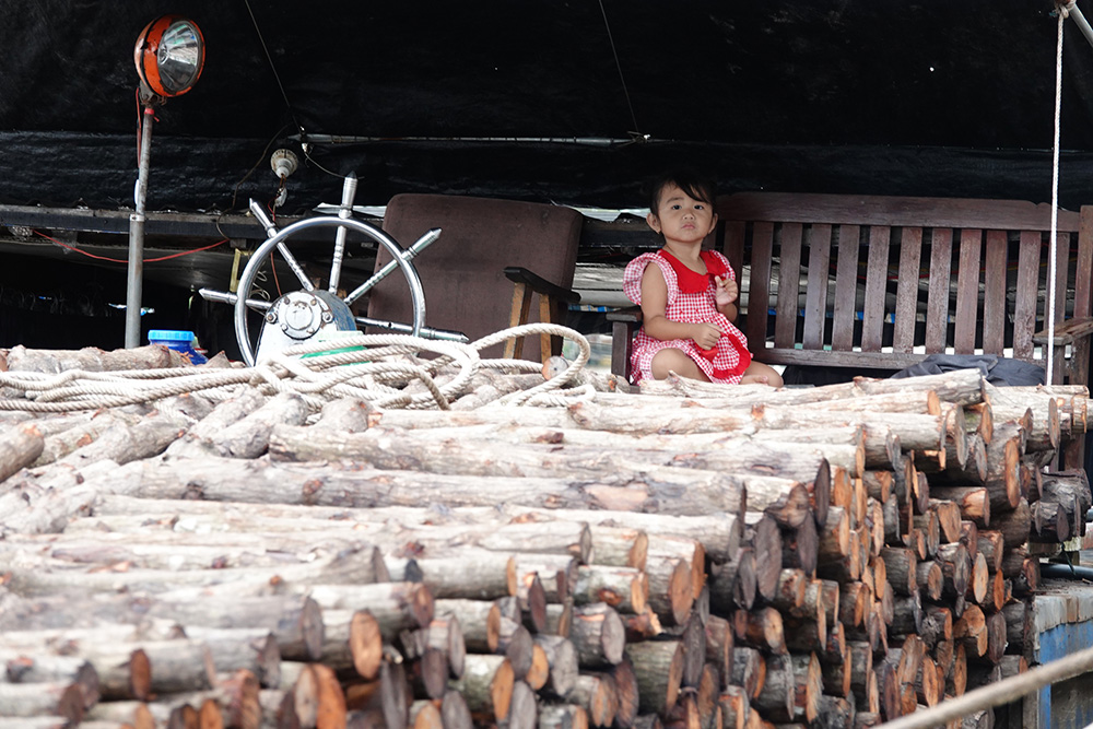 Trẻ con theo cha mẹ sống trên ghe bán củi. ẢNH: DUY TÂN