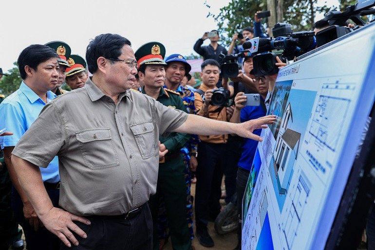 Thủ tướng Phạm Minh Chính nghe báo cáo về thiết kế nhà chống lũ. (Ảnh: VGP/Nhật Bắc)