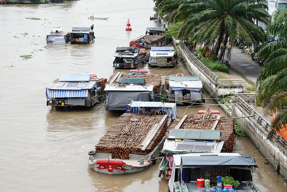Các ghe củi neo đậu san sát dưới chân cầu Phụng Hiệp tạo nên khu chợ nổi độc đáo trên sông Cái Côn. ẢNH: DUY TÂN