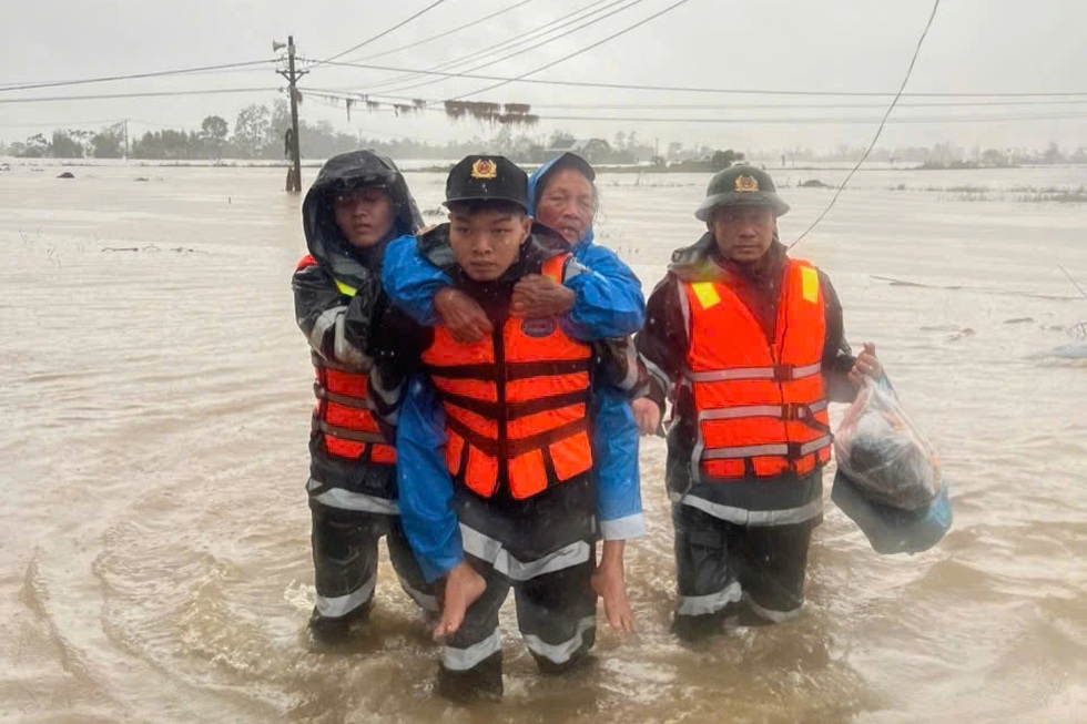 Cán bộ, chiến sĩ Trung đoàn Cảnh sát cơ động Tây Nguyên giúp người dân vùng lũ đến nơi an toàn (Ảnh: Uy Nguyễn).