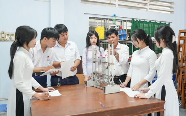 Thầy Bùi Văn Tròn cùng học sinh thực hành thí nghiệm Vật lý.

