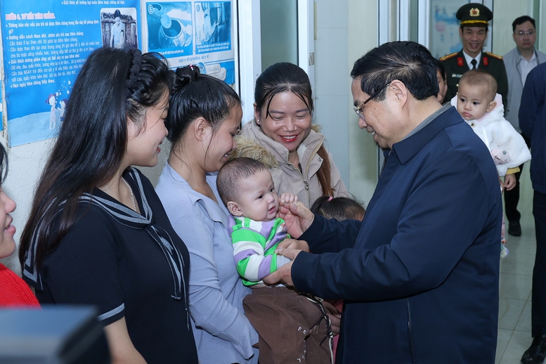 Thủ tướng Phạm Minh Chính thăm hỏi người dân đến khám tại trạm y tế xã Yên Khương - Ảnh: VGP/Nhật Bắc