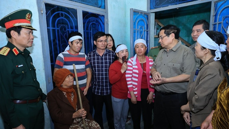 Thủ tướng Phạm Minh Chính thăm, động viên thân nhân gia đình có người bị thiệt mạng do mưa lũ. (Ảnh: VGP/Nhật Bắc)