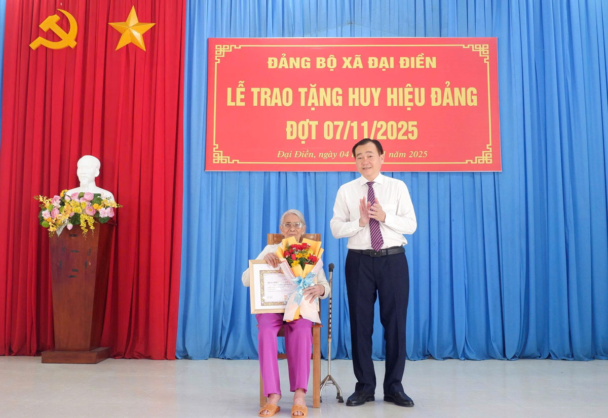 Đồng chí Nguyễn Minh Dũng- Phó Bí thư Tỉnh ủy, Chủ tịch HĐND tỉnh trao Huy hiệu 60 năm tuổi Đảng cho đảng viên Dương Thị Minh Hải.