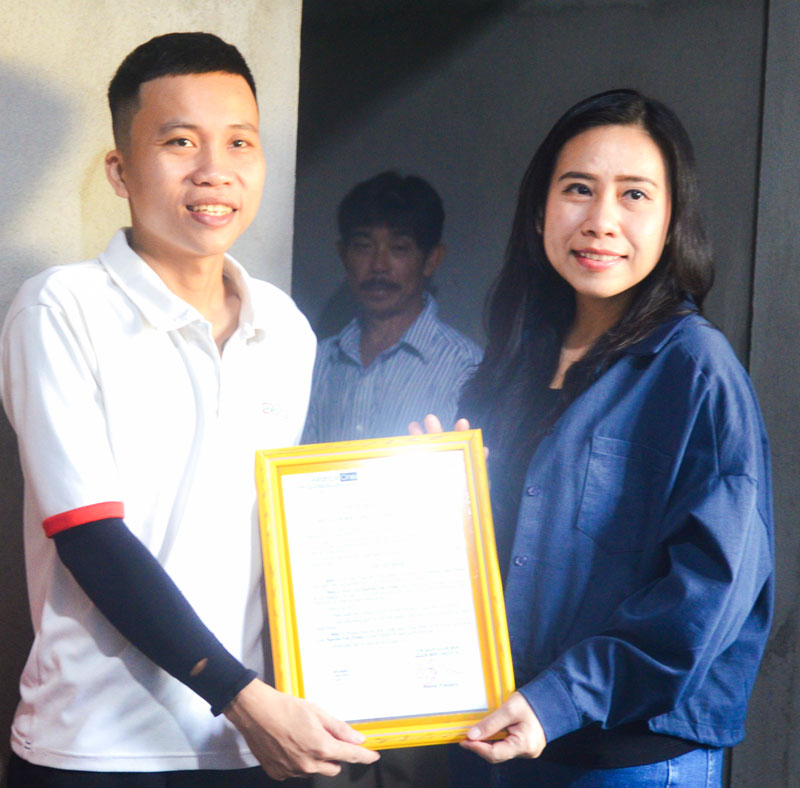 Bà Posree Pimnara- Giám đốc nhân sự Công ty TNHH May mặc Alliance One trao quyết định bàn giao nhà cho CNLĐ Nguyễn Văn Trung.